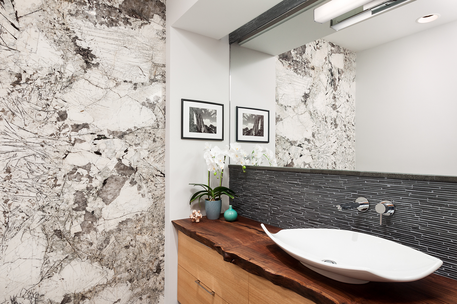 grey, white, and black marble wall with wood counter and sink for a contemporary bathroom