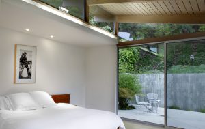 contemporary bedroom with large sliding door leading to side patio