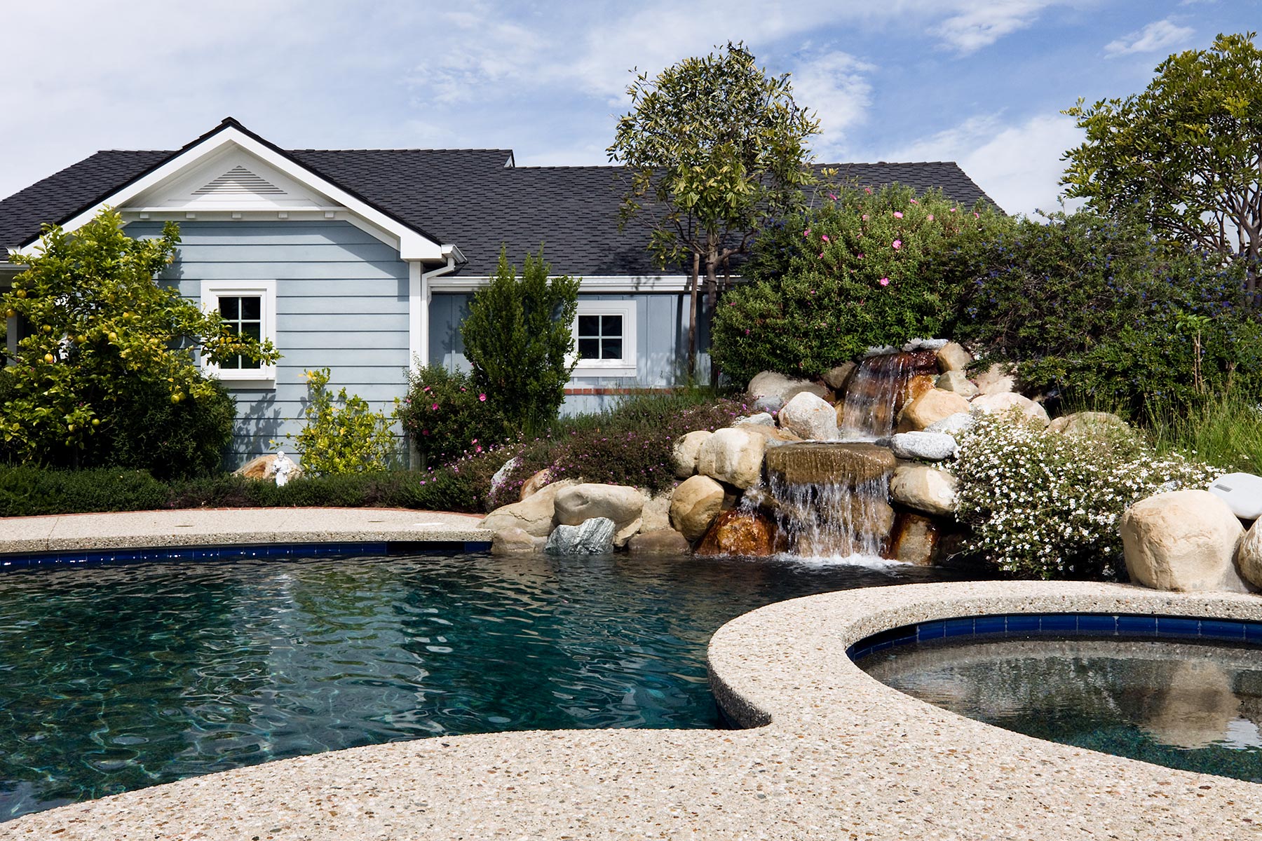 backyard view of preston house with pool and small waterfall