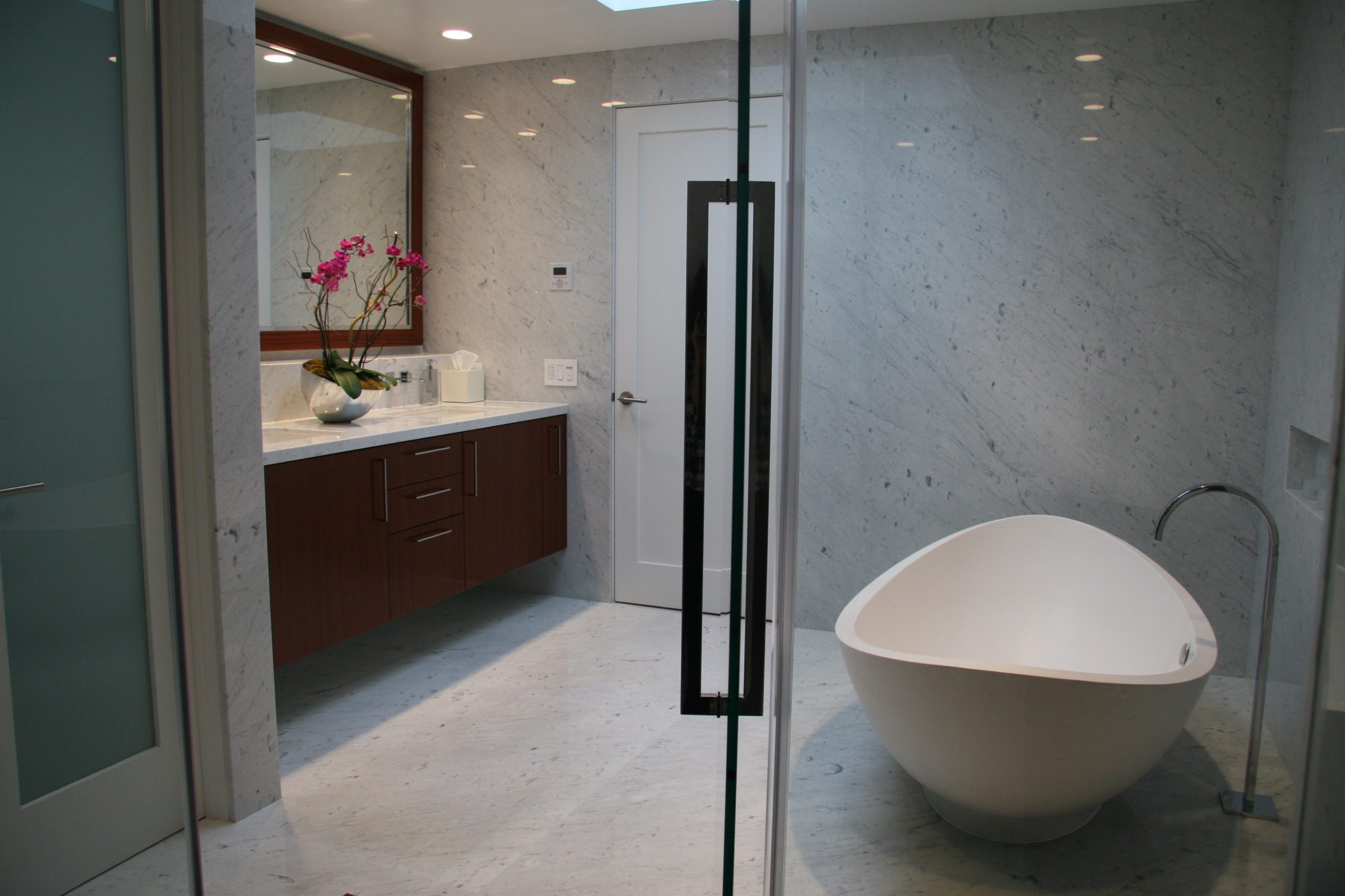 marbled walls and floor bathroom with contemporary bathtub